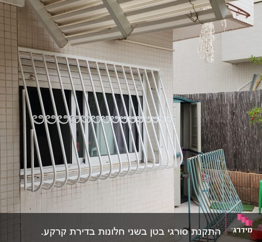סורגי מתכת לבנים על חלון קיר חיצוני